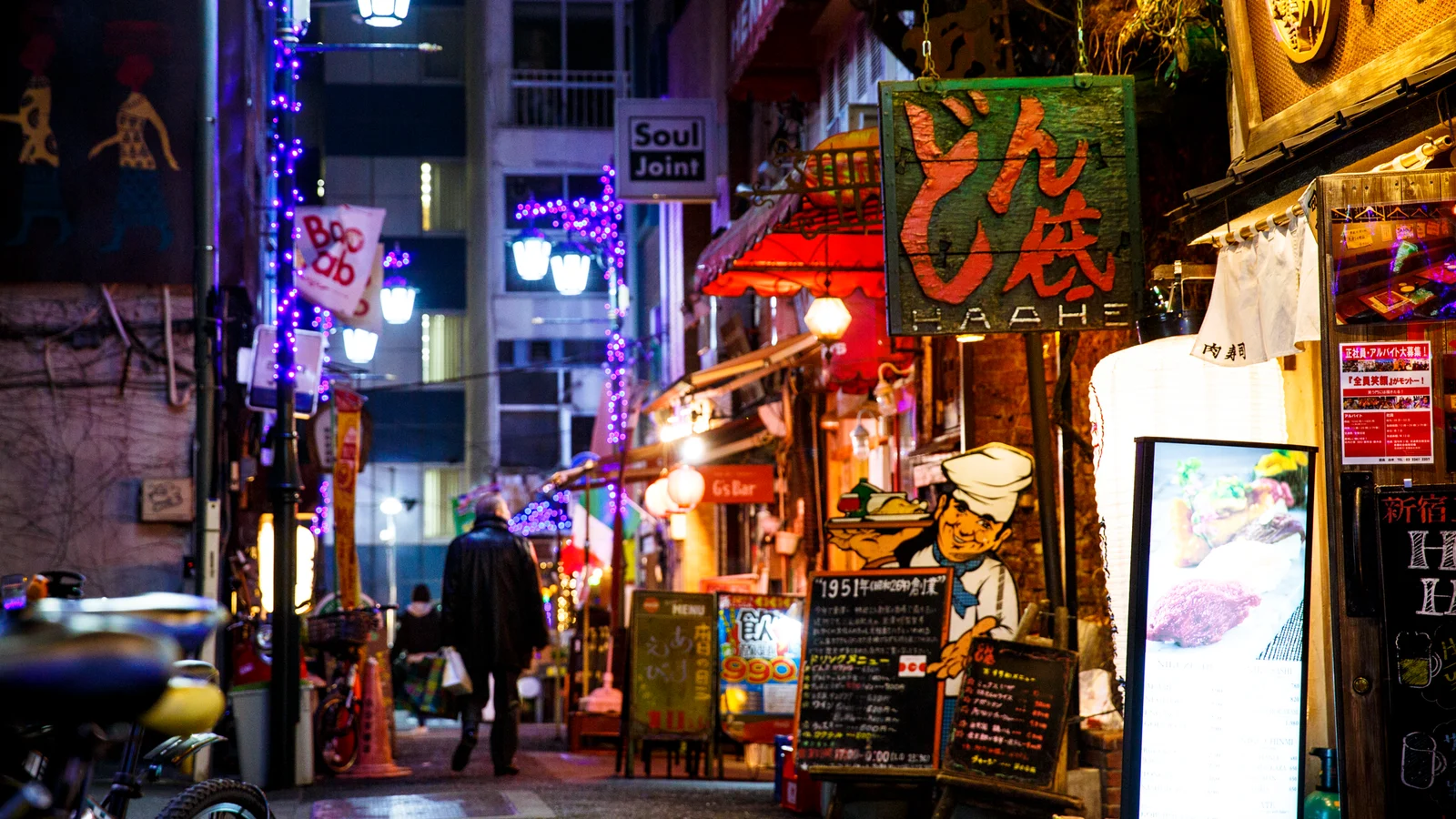 Lanterns and colourful signs in a Shinjuku-sanchōme alley at night, beside Donzoko