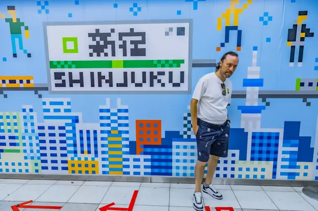 Renaud posing beside a colourful Shinjuku mural