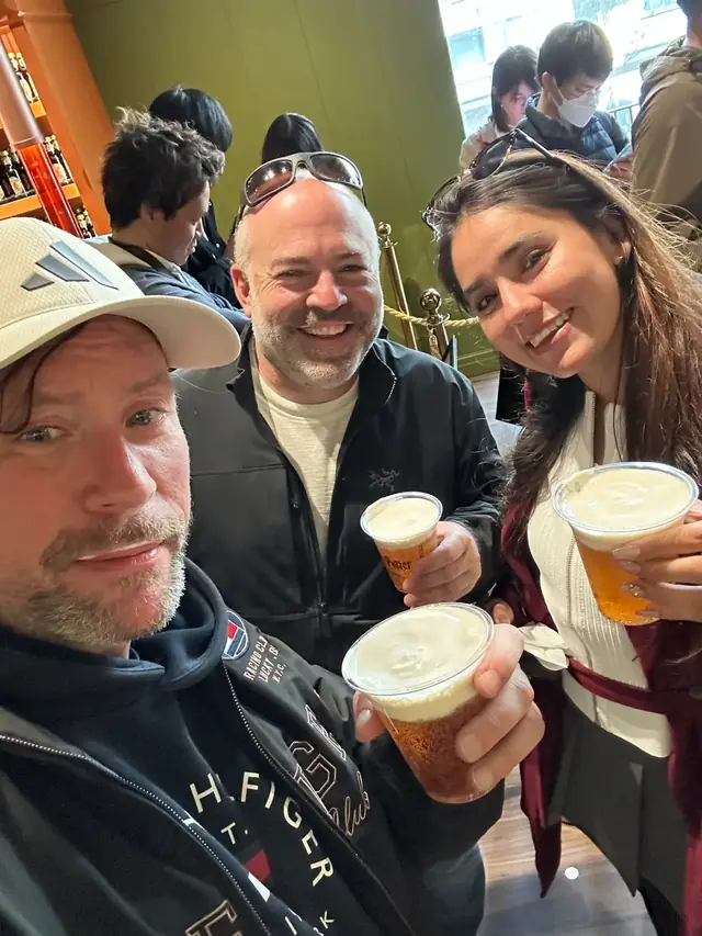 Renaud and two guests sharing a beer break indoors in Tokyo