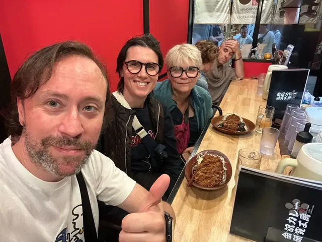Renaud and guests at a restaurant counter with plates of food