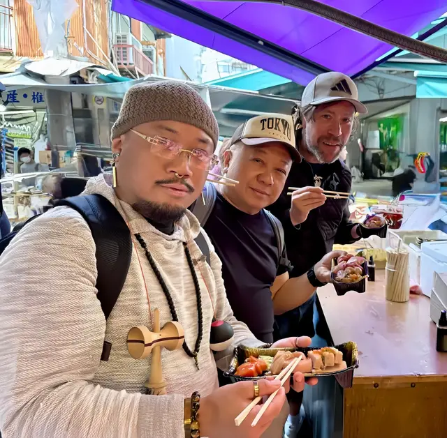 Renaud and two guests sharing seafood at a market counter