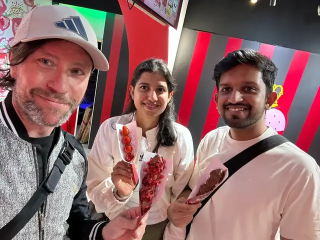 Renaud and two guests holding fruit sweets