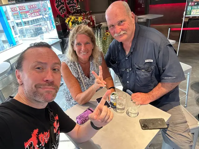 Renaud and two guests smiling around a restaurant table