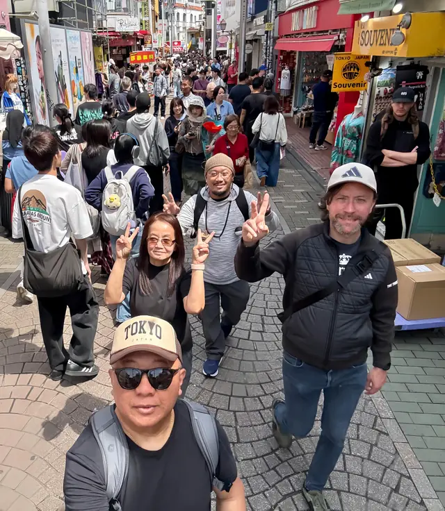 A local guide and guests exploring a busy Tokyo street on foot