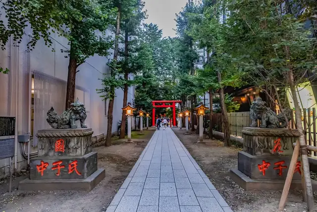 Tree-lined shrine approach with red torii in Shinjuku