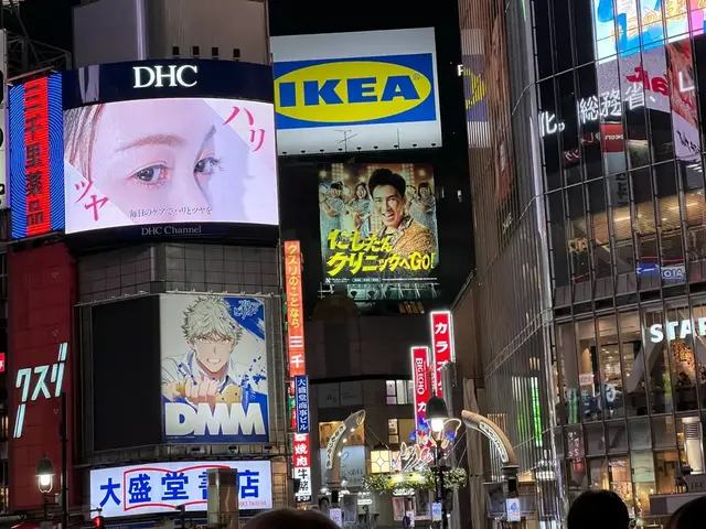 Shibuya after dark — bright signs above the busy streets.