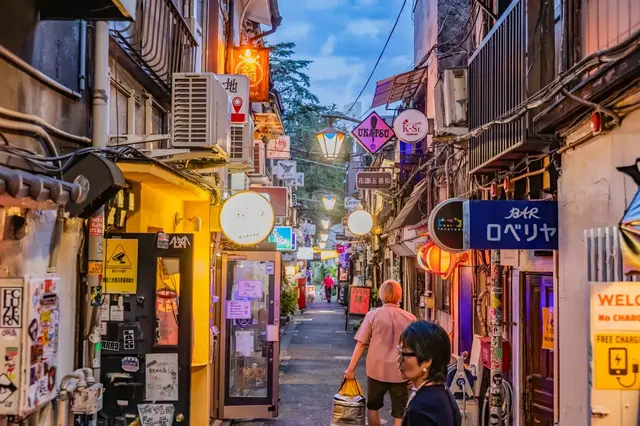 Golden Gai at dusk — narrow lanes, tiny bars and glowing signs.