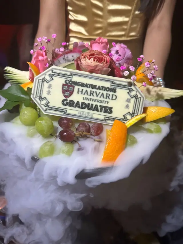 Fruit and flower platter with mist and a plaque congratulating Harvard University graduates