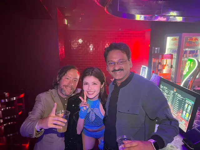 Renaud and guests together beneath colourful nightlife lights